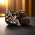 Fresh Tuber brumale A Grade Black Winter Truffle with a textured dark exterior and exposed marbled interior