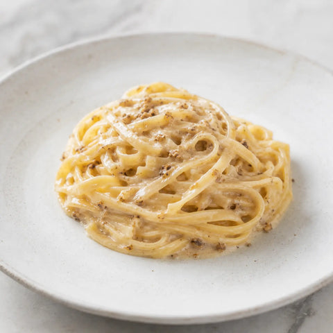Creamy pasta with finely chopped frozen Tuber magnatum white truffle