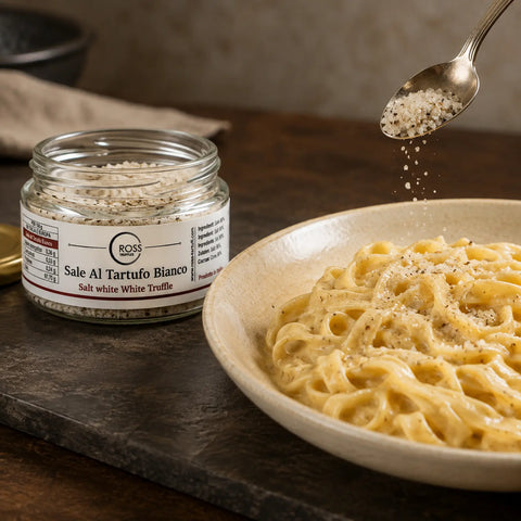 White truffle salt being sprinkled over warm creamy tagliatelle before serving